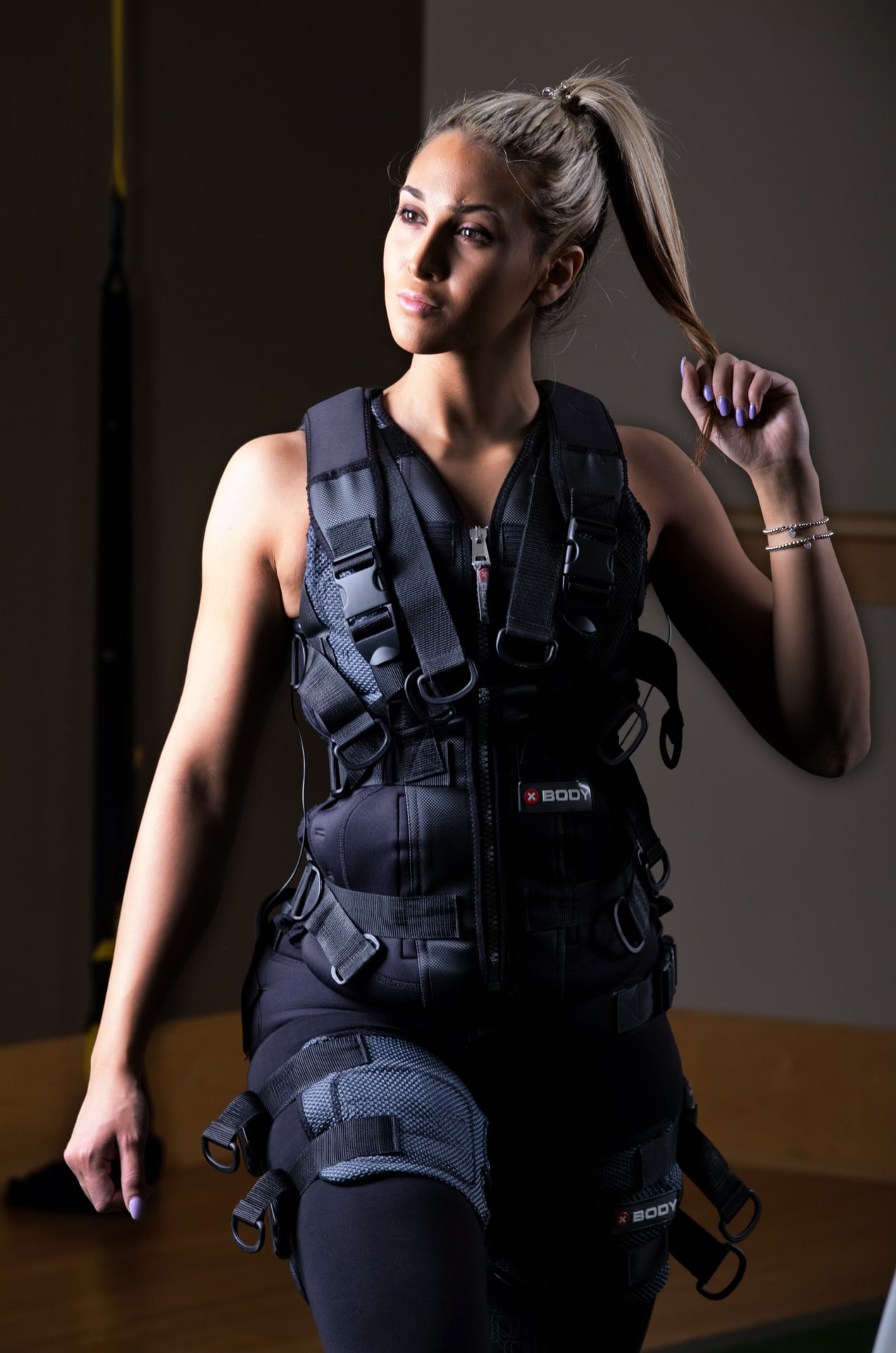 Trainer fitting an EMS training suit on a client